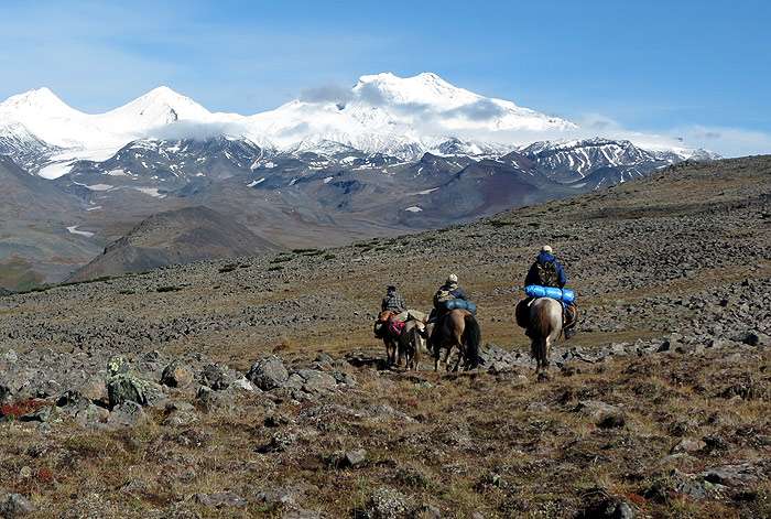 Три всадника едут на лошадях высоко в горах, фото фотография