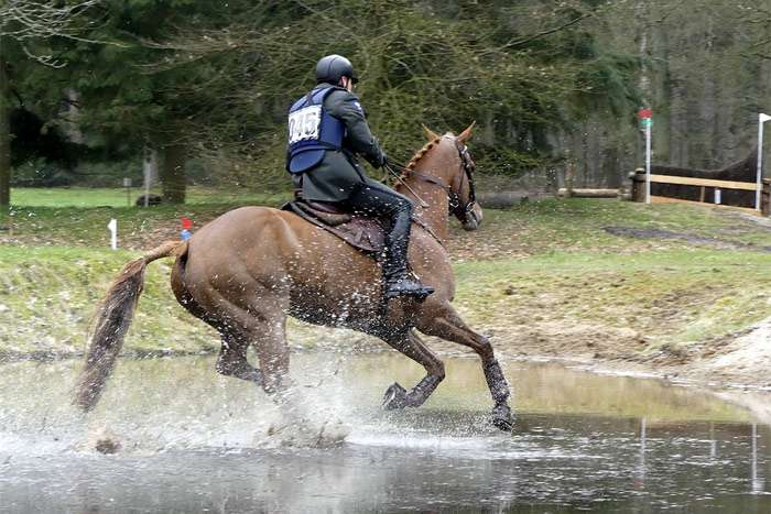 Всадник на лошади преодолевает водное препятствие, фото фотография